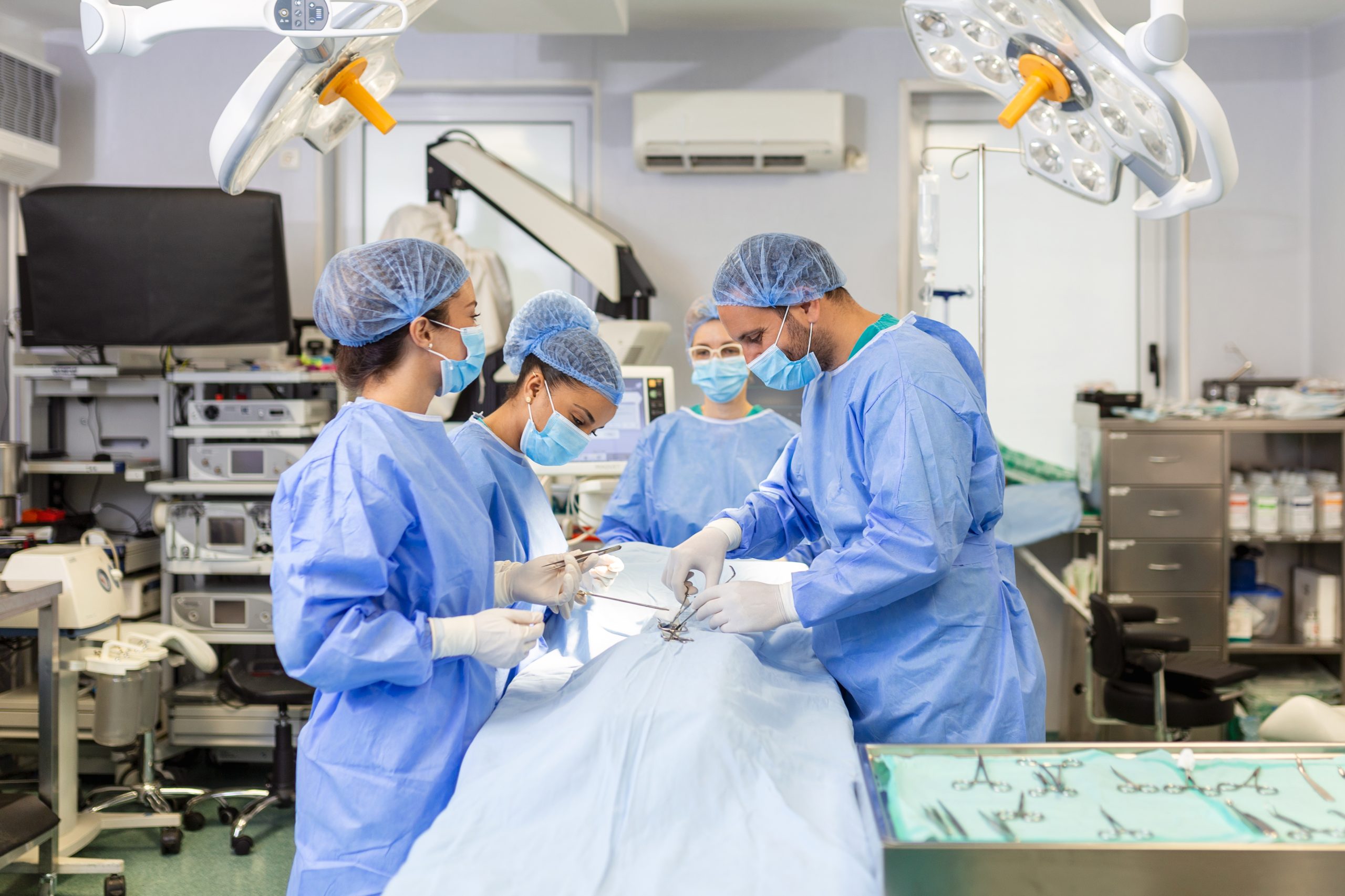 Team of professional doctors performing operation in surgery room. Medical Team Performing Surgical Operation in Bright Modern Operating Room